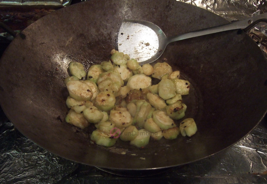 Stir-frying Chinese okra in a wok
