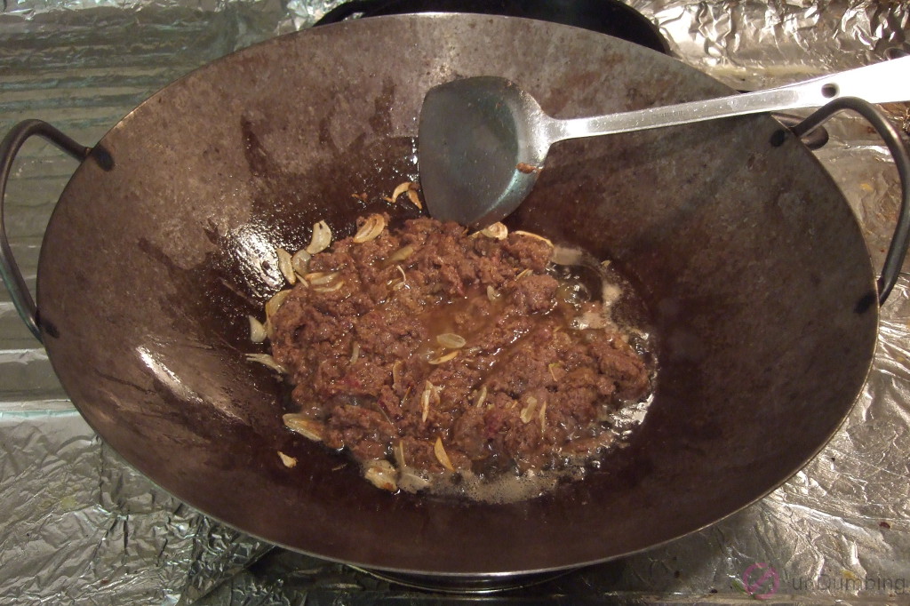 Stir-frying beef with garlic in a wok