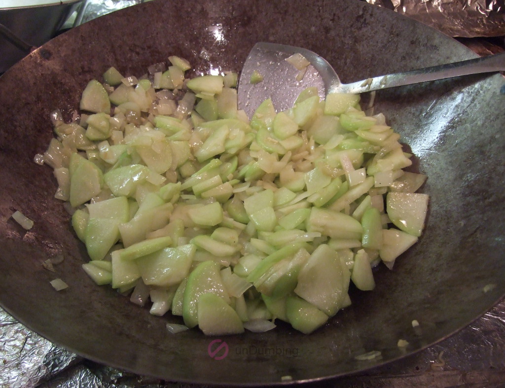 Cooked chayote squash in a wok