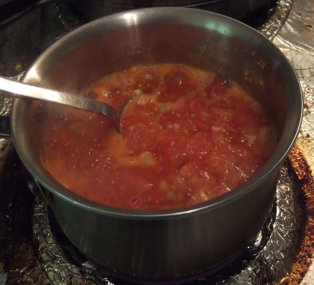 Sautéed tomatoes, green onions, and garlic in a saucepan
