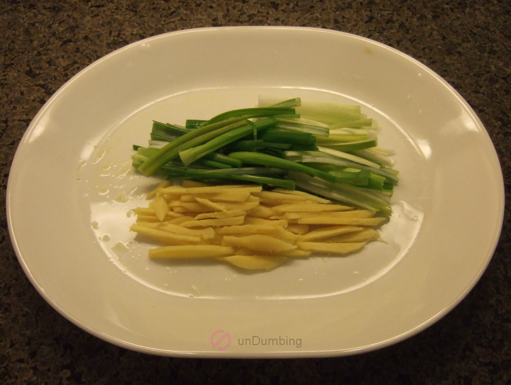 Julienned scallions and ginger on a white plate