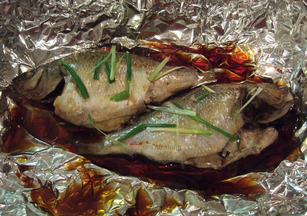 Sauce and oil over steamed perch on a foil-lined roasting pan