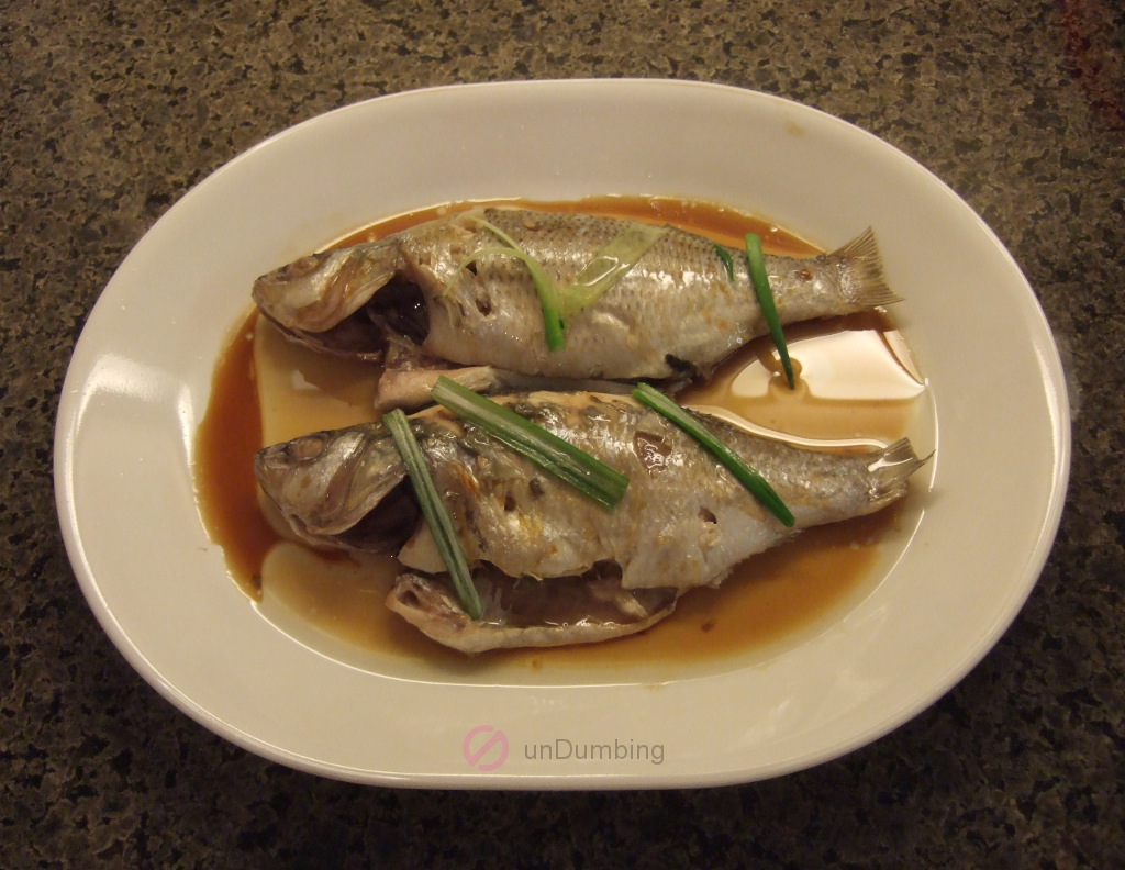 Sauce and oil over steamed perch on a white plate