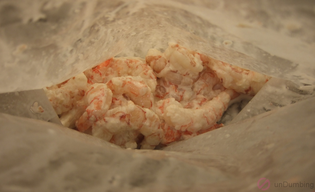 Shrimp coated with corn starch inside a plastic freezer bag