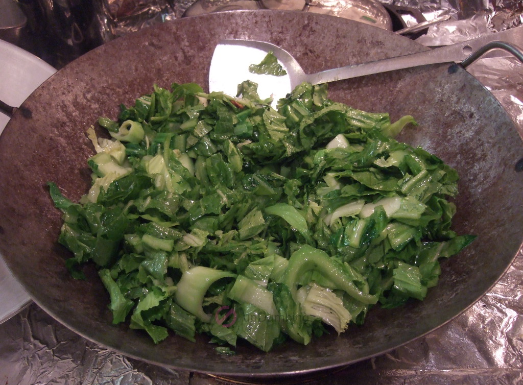 Stir-frying Chinese mustard greens in a wok