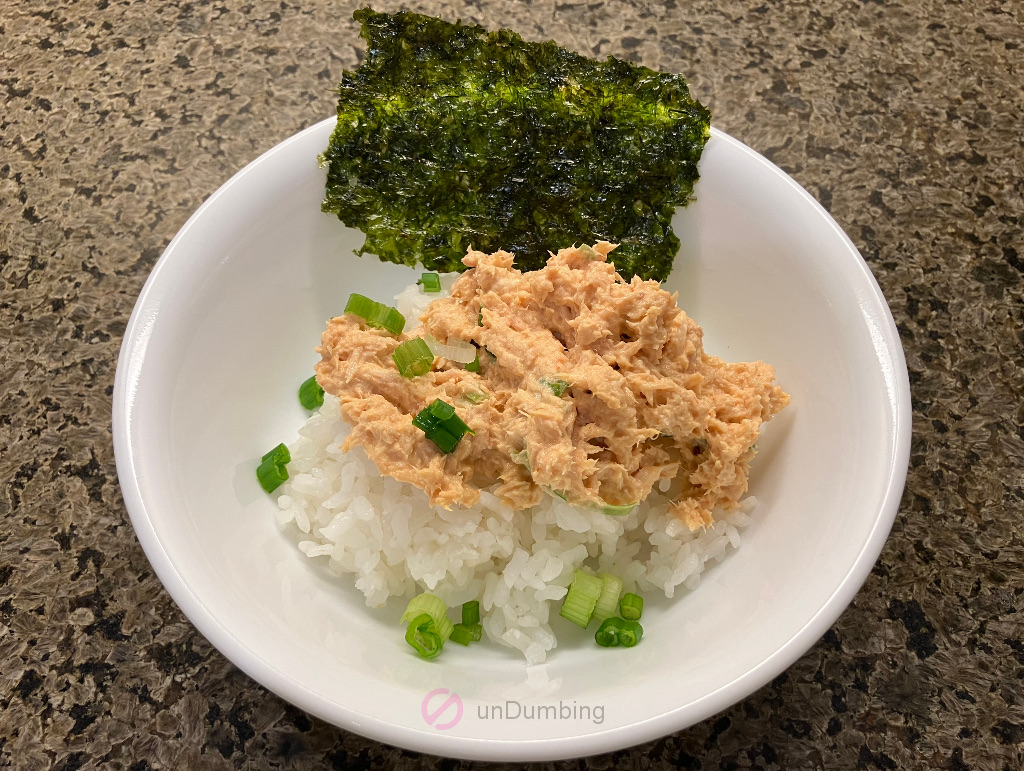 Japanese spicy tuna salad in a white bowl with seaweed and chopped scallion