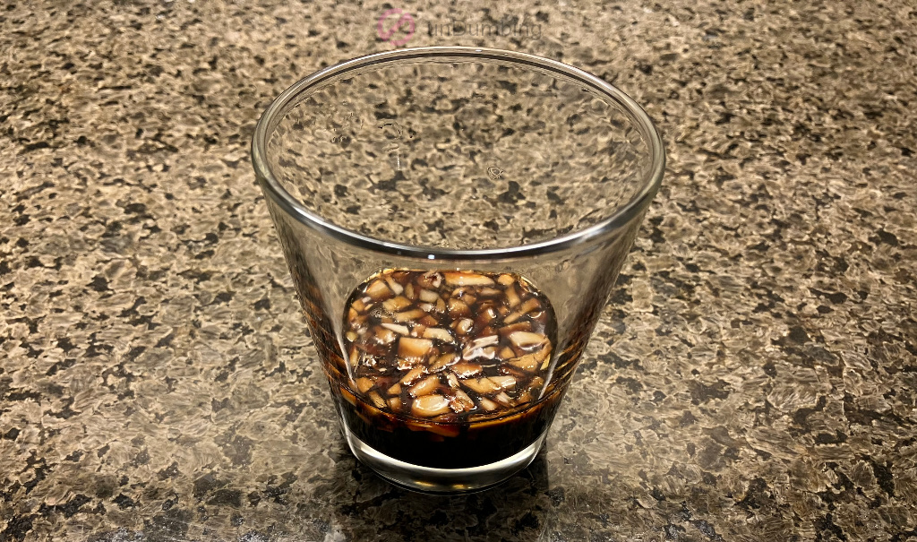 Minced garlic and soy sauce in a shot glass