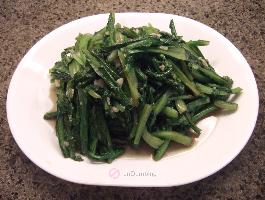 Stir-fried A Choy on a white plate