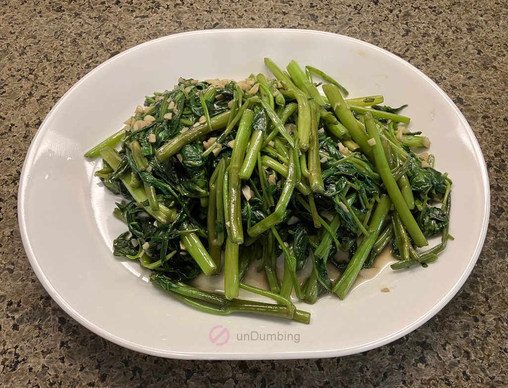 Stir-fried ong choy on a white plate