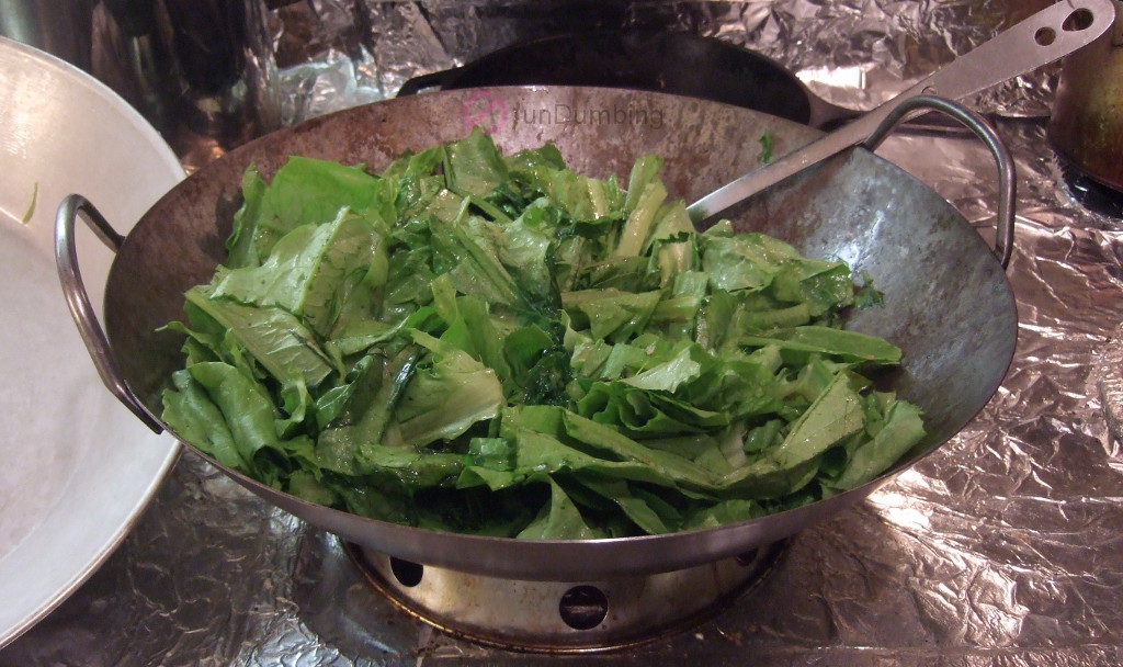 Stir-frying A Choy in a wok