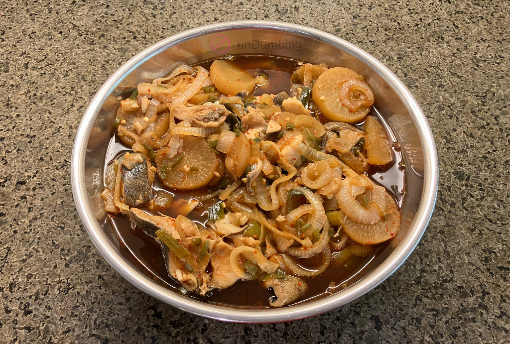 Braised black cod with daikon in a stainless steel bowl