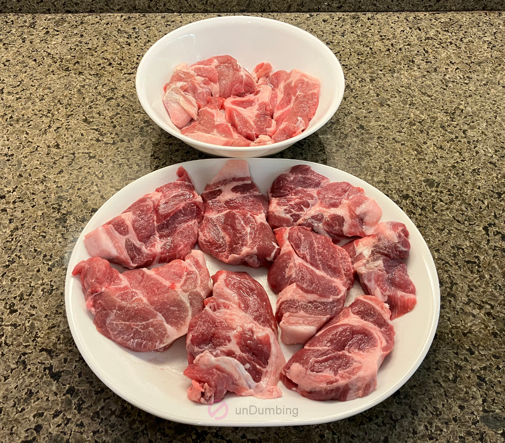 White bowl and plate of salted pork blade steaks