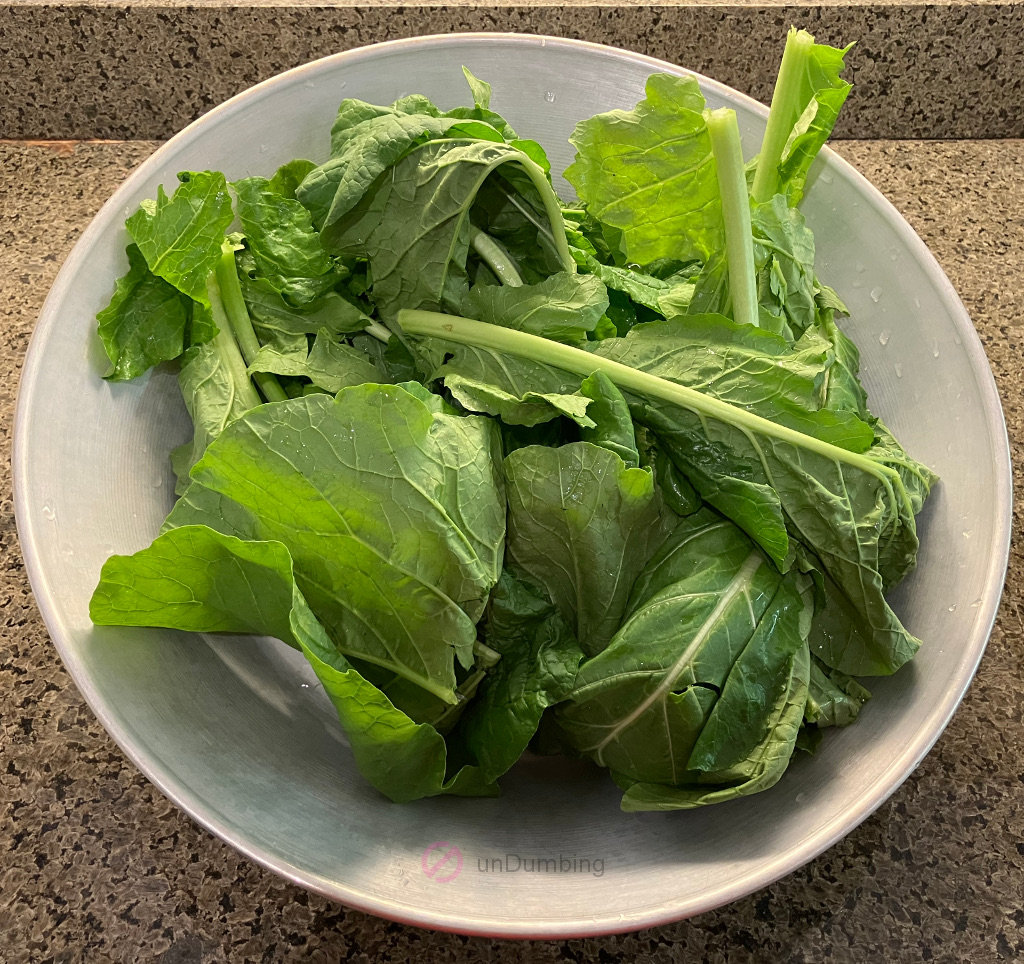 Washed and trimmed turnip greens in a wok cover